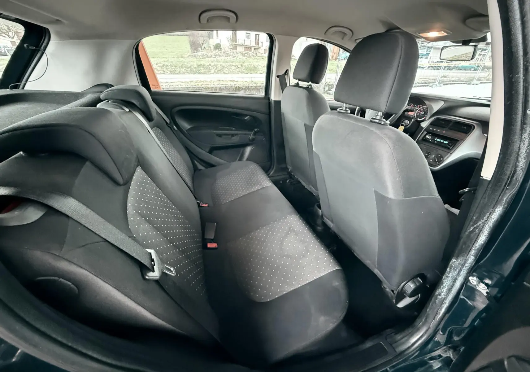 Vue intérieure arrière côté droit du Fiat Punto noire de 2009, montrant les sièges arrière et l'avant du véhicule.