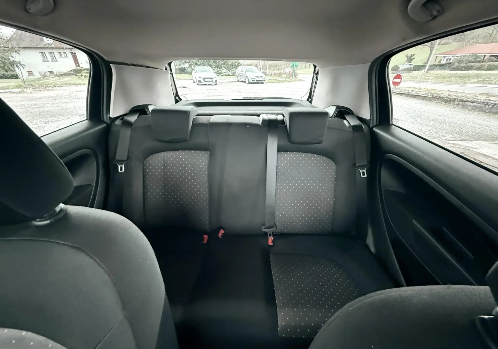 Vue intérieure arrière montrant les sièges noirs avec motifs à petits points du Fiat Punto 1.2 i 65 de 2009.