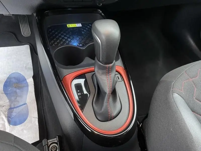 Gros plan sur le levier de vitesses automatique de la Toyota Aygo X 2023, avec surpiqûres rouges et contour rouge piment.