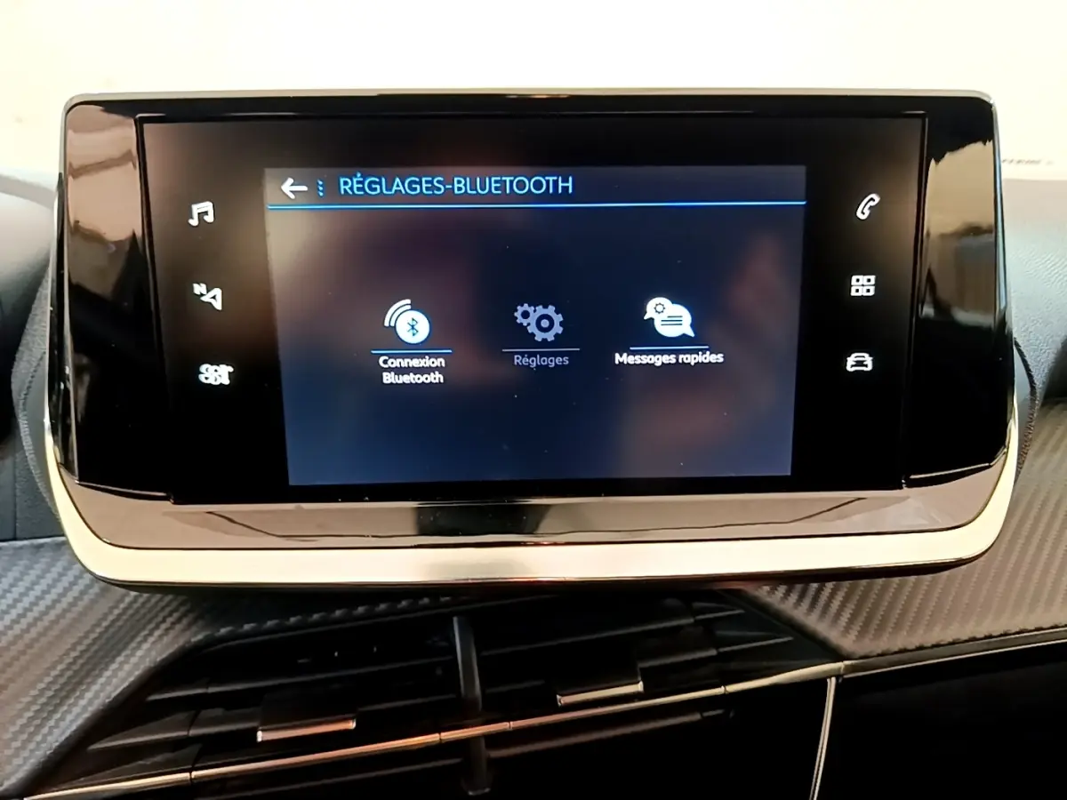 Écran tactile central du tableau de bord du Peugeot 2008 blanc, affichant les réglages Bluetooth.