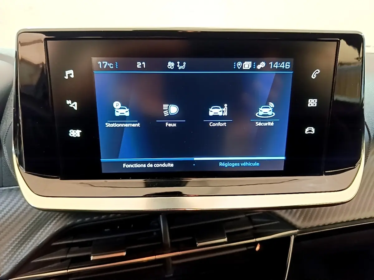Écran tactile central du tableau de bord du Peugeot 2008 blanc, affichant les réglages de conduite et sécurité.