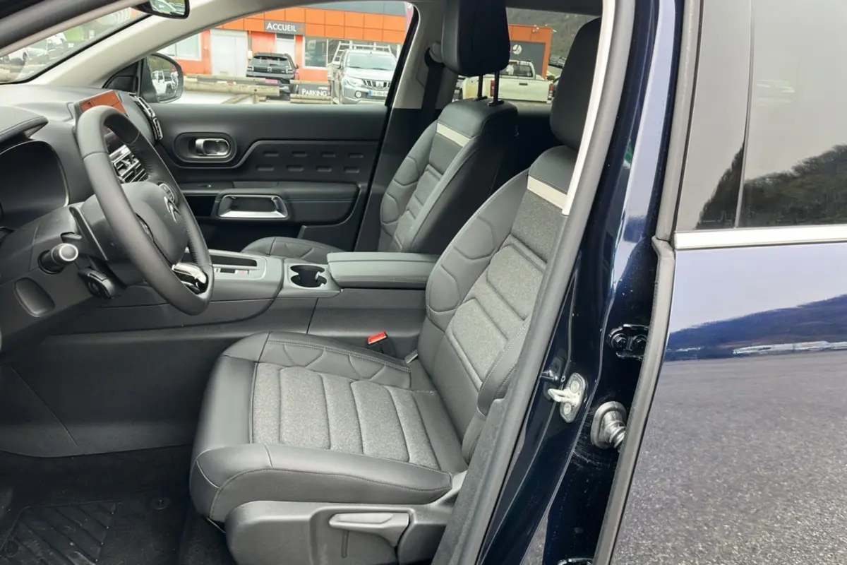 Vue intérieure côté conducteur du Citroën C5 Aircross Hybrid 145 en Eclipse Blue, sièges confort bi-matière gris et noir.