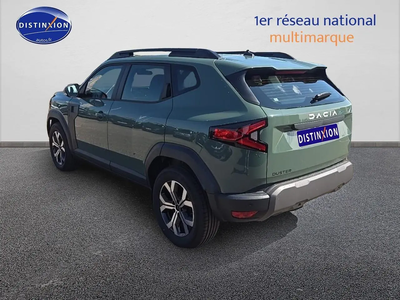 Vue 3/4 arrière droite d'un Dacia Duster vert kaki 2025 avec barres de toit et jantes alliage.