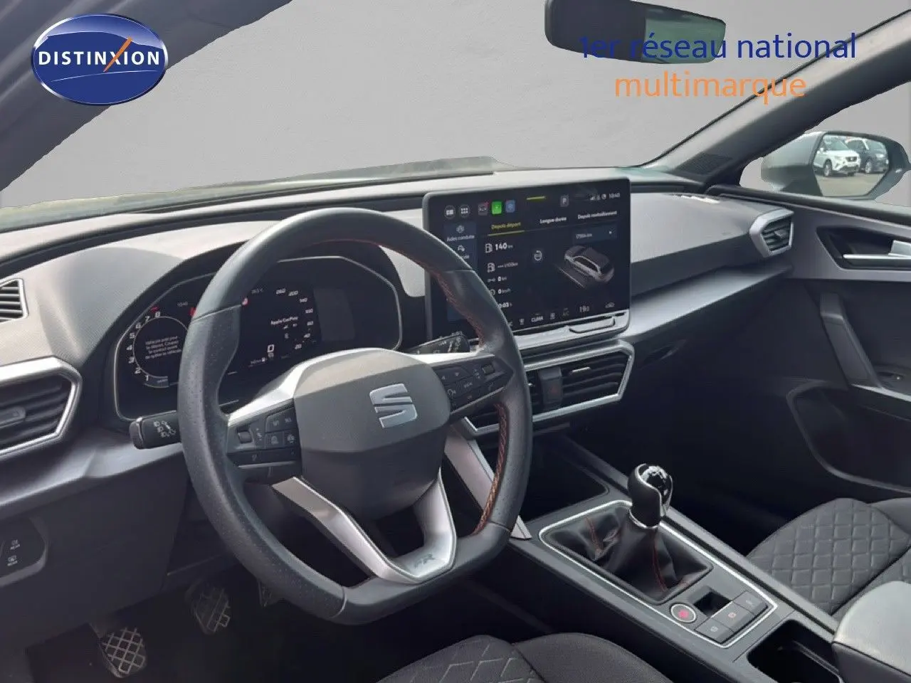 Intérieur de la SEAT LEON ST 2025, vue du poste de conduite avec volant multifonction et écran tactile central.