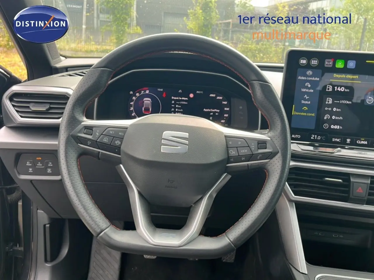 Vue intérieure centrée sur le volant perforé et le tableau de bord numérique du SEAT LEON ST gris métallique.