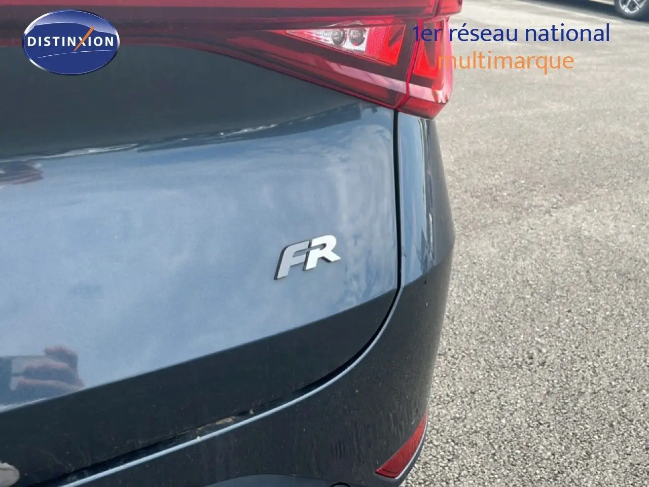 Gros plan sur l'arrière droit gris magnétique métallisé du SEAT LEON ST 1.5 TSI FR avec logo FR et feu arrière visible.