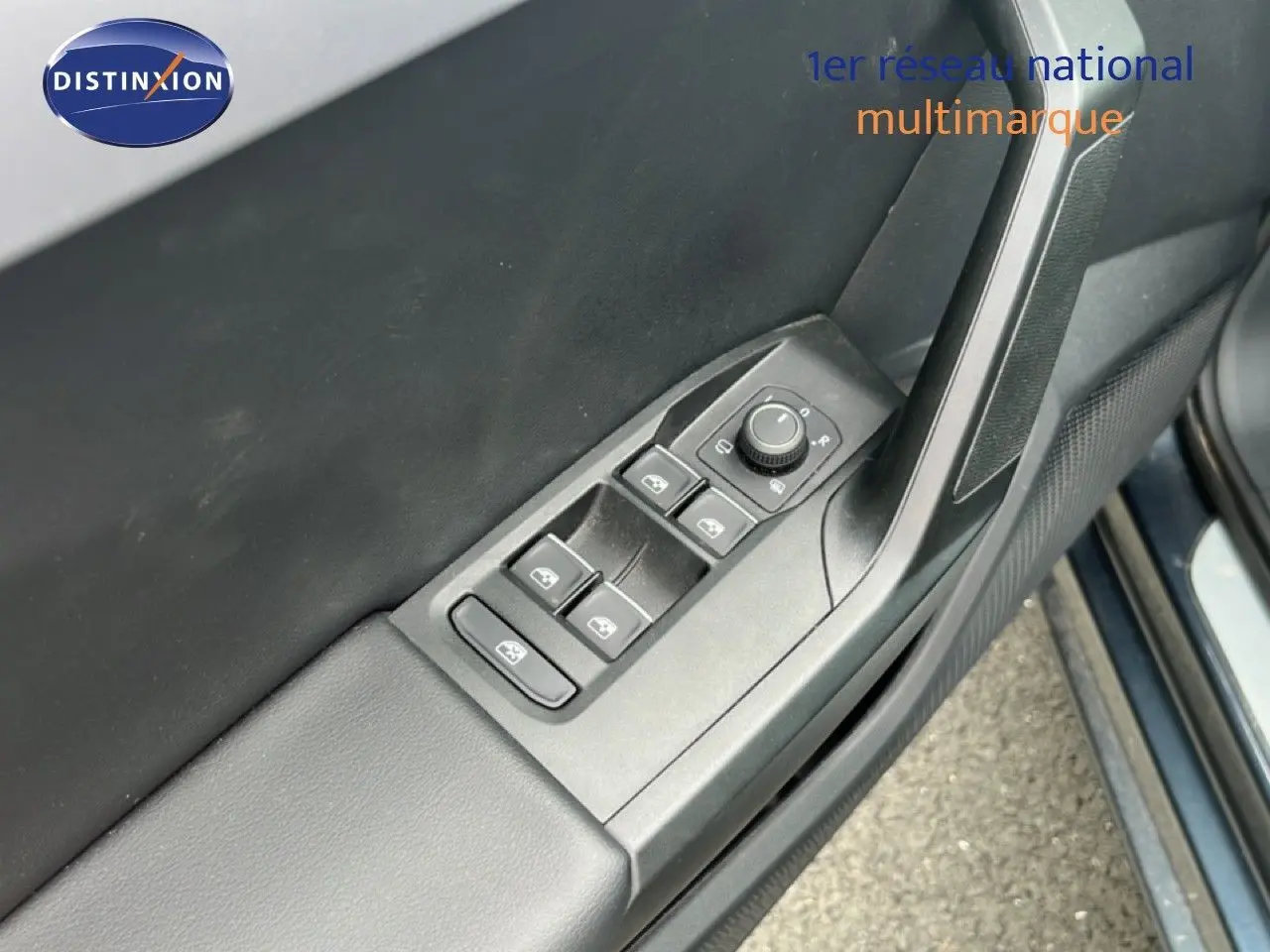 Détail de la commande des vitres électriques et réglage des rétroviseurs sur la porte côté conducteur d’une SEAT LEON ST gris magnétique.