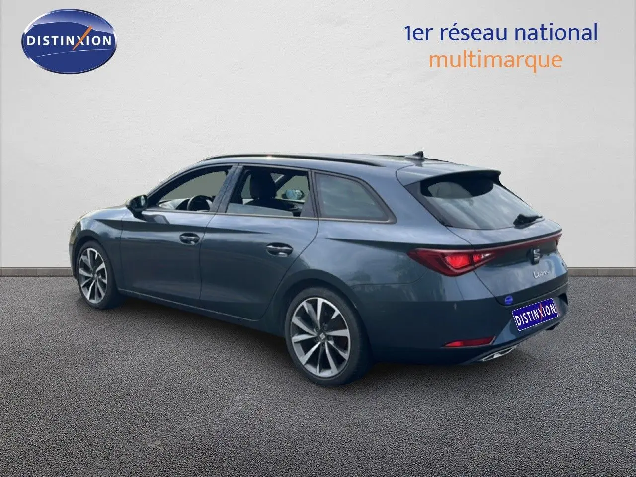 SEAT Leon ST gris magnétique métal vue 3/4 arrière droit, avec jantes alliage et feux arrière LED allumés.