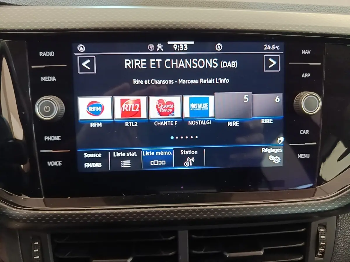 Écran tactile central du Volkswagen T-Cross blanc 2022 affichant la radio numérique avec plusieurs stations visibles.