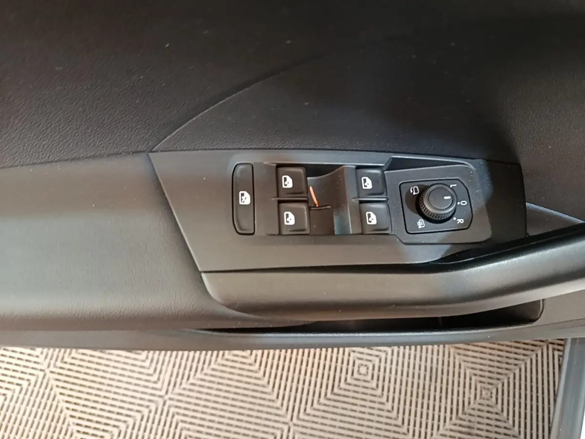 Gros plan sur les commandes des vitres et rétroviseurs côté conducteur d'un Volkswagen T-Cross blanc 2022.