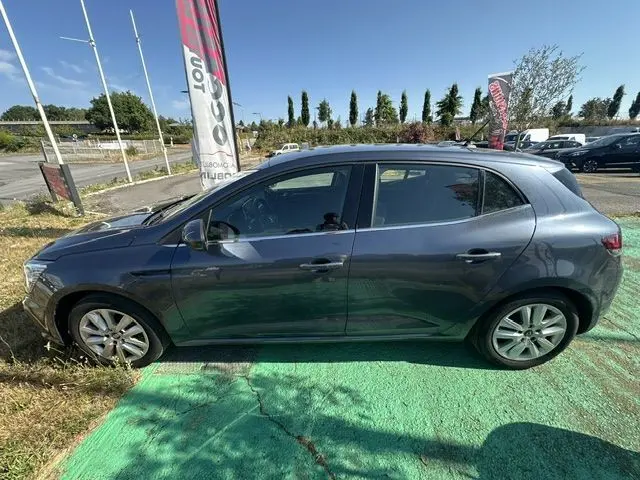 Vue latérale côté gauche d'une Renault Mégane bleu 2021, version diesel 1.5 Blue dCi Business, sur parking extérieur.