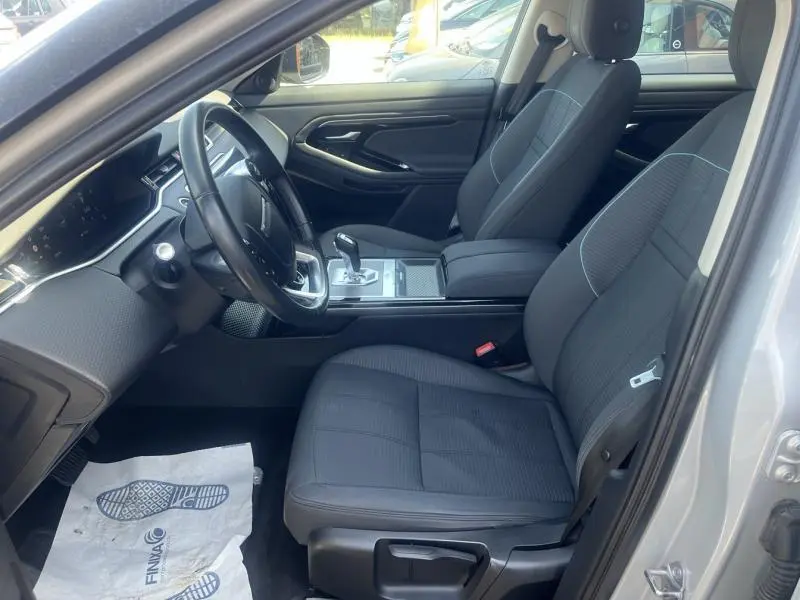 Intérieur du Range Rover Evoque 2019 en Indus Silver, vue côté conducteur sur sièges noirs et tableau de bord moderne.