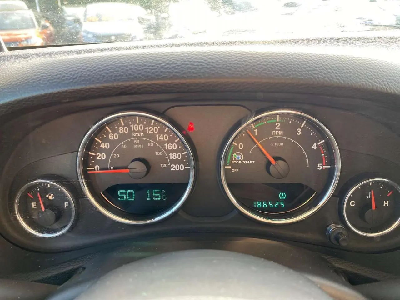 Tableau de bord du Jeep Wrangler 2012 montrant les compteurs de vitesse, régime, carburant et température moteur.