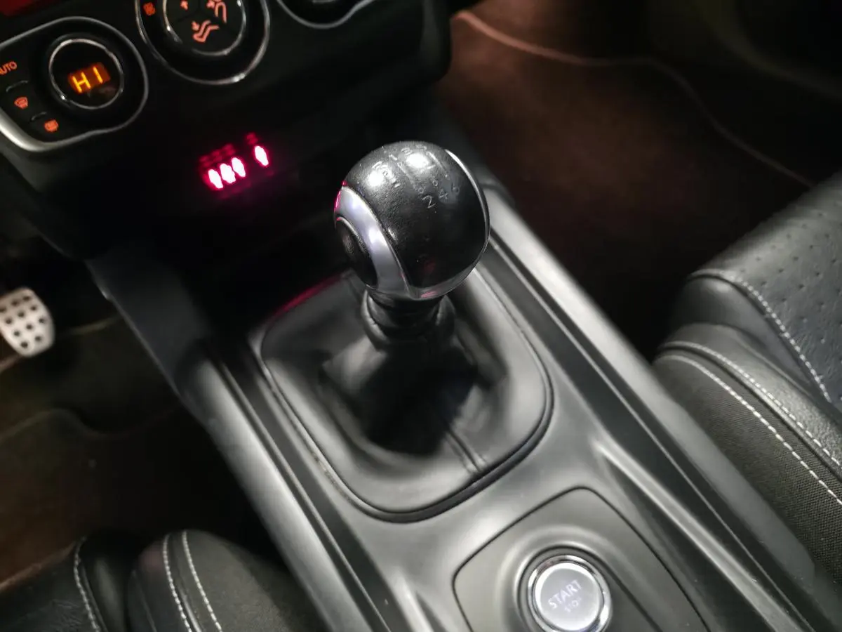 Gros plan sur le levier de vitesses manuel noir et la console centrale du DS4 diesel violet, intérieur cuir noir.