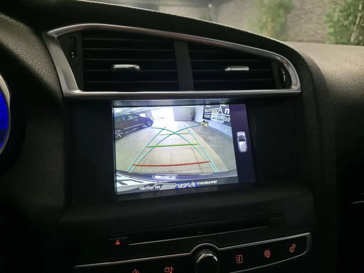 Écran tactile intérieur montrant la caméra de recul d'une DS4 violet avec guidage de trajectoire en garage.