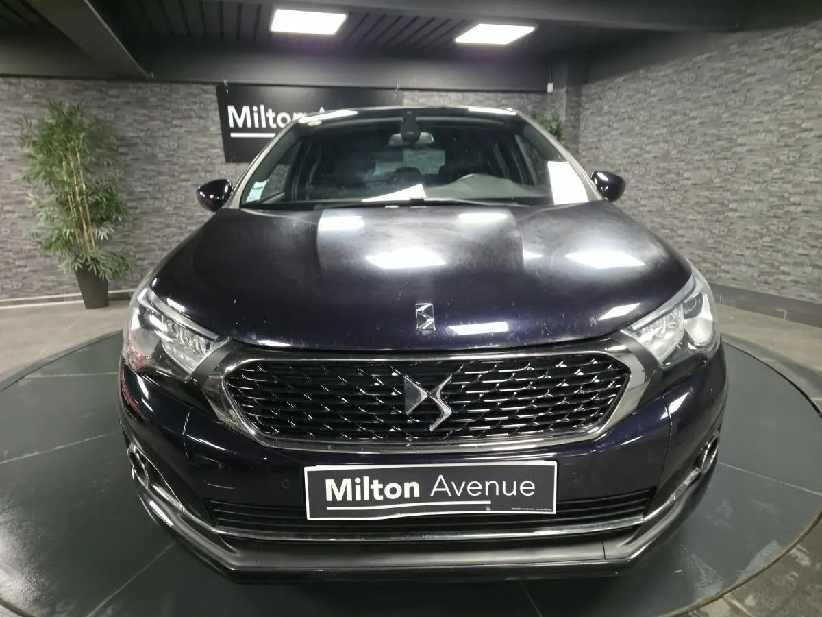 Vue frontale rapprochée d'une DS4 2016 violet métallisé avec calandre DS distinctive et phares LED élégants.