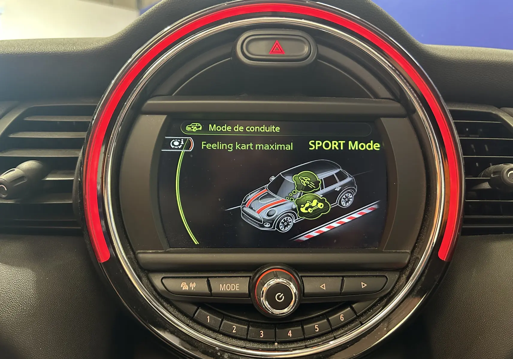 Écran central rond du tableau de bord MINI Cooper D 2015 affichant le mode de conduite Sport avec éclairage rouge.