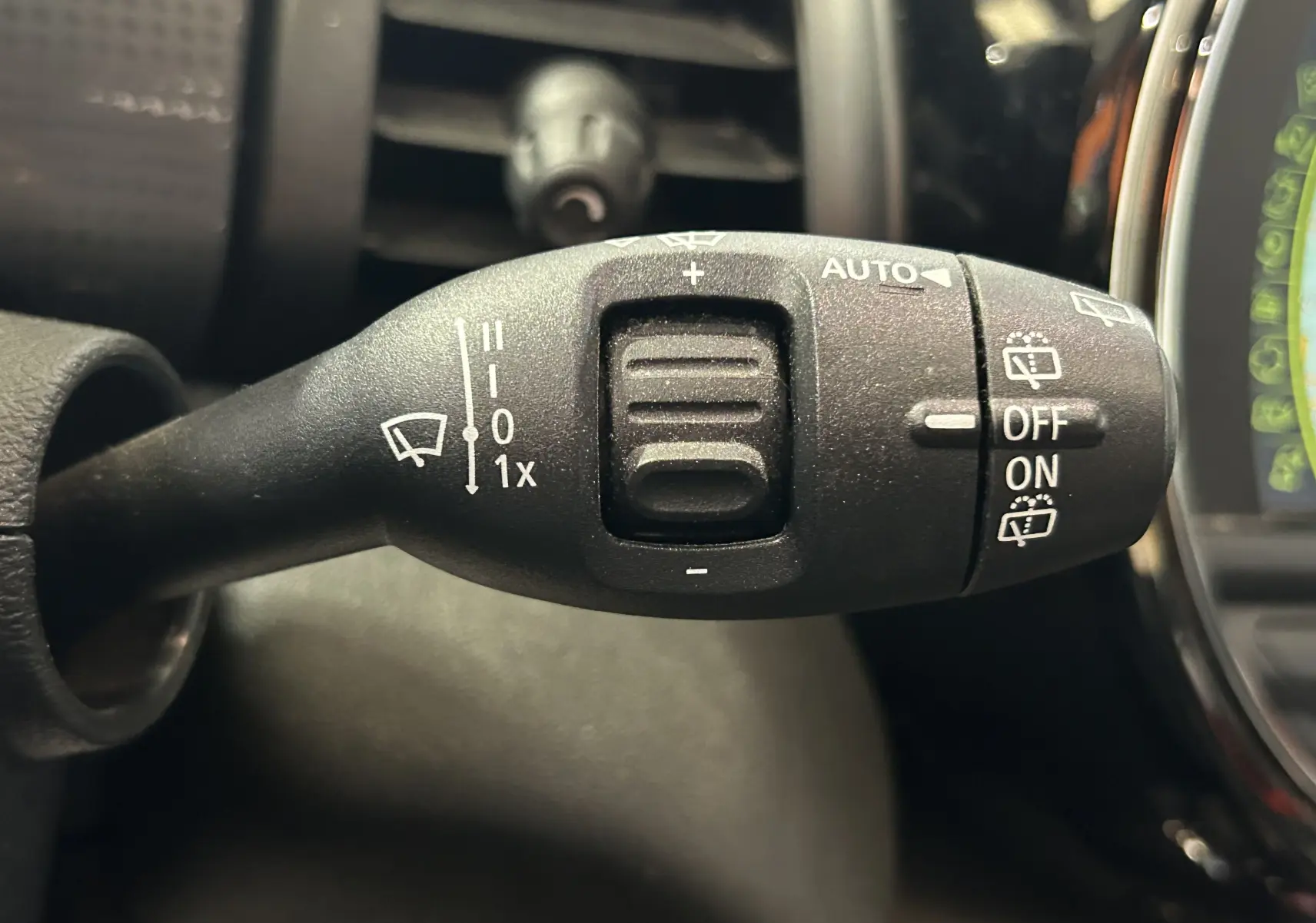 Gros plan sur la commande des essuie-glaces à gauche du volant dans l'habitacle d'une MINI 5P.
