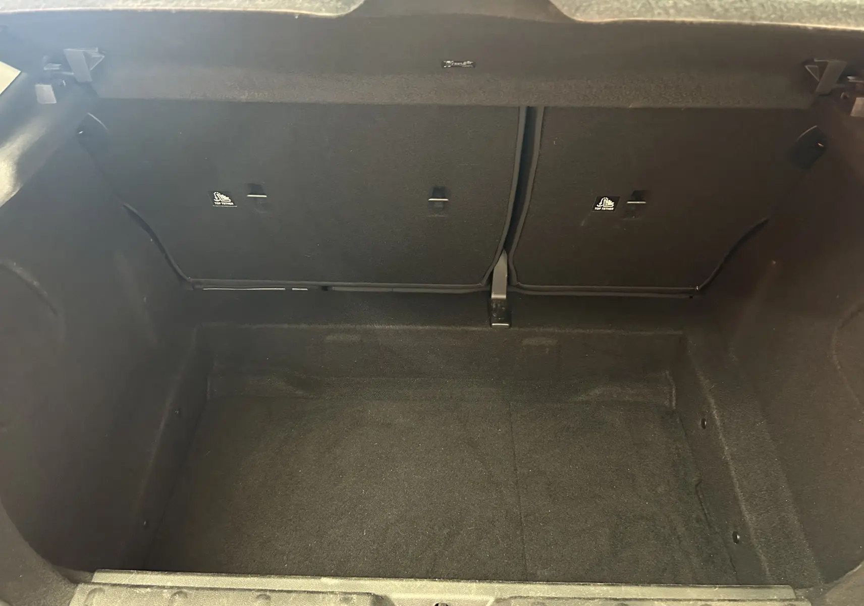 Coffre vide de MINI 5 portes Cooper D bleu, vue intérieure montrant l'espace de chargement et les dossiers arrière rabattables.