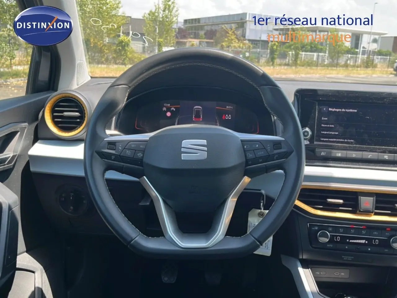 Vue intérieure centrée sur le volant de la SEAT Arona gris Magnetic, avec tableau de bord digital et détails dorés.