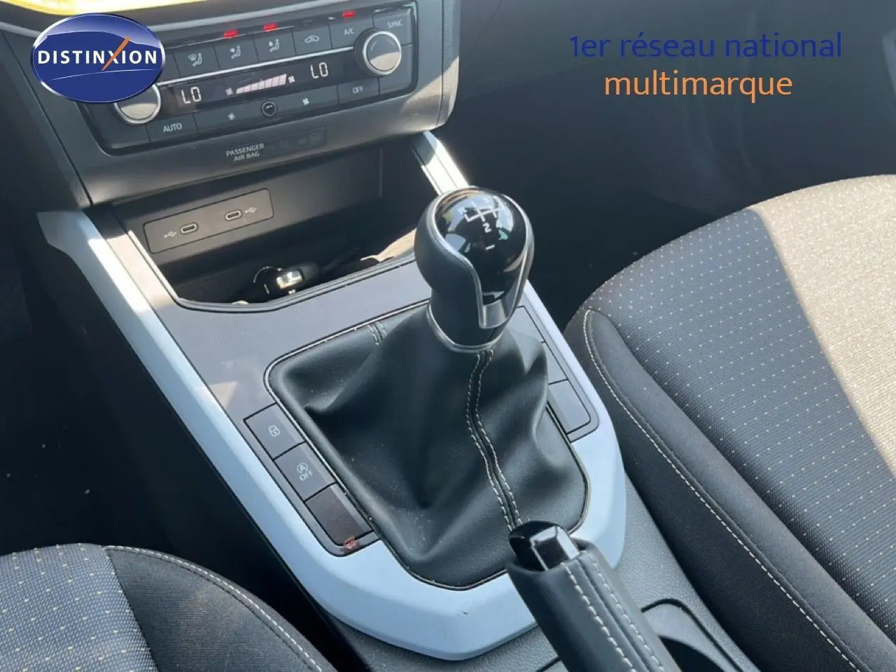 Vue rapprochée de la console centrale du SEAT Arona 2025, avec levier de vitesse manuel et sellerie tissu gris.