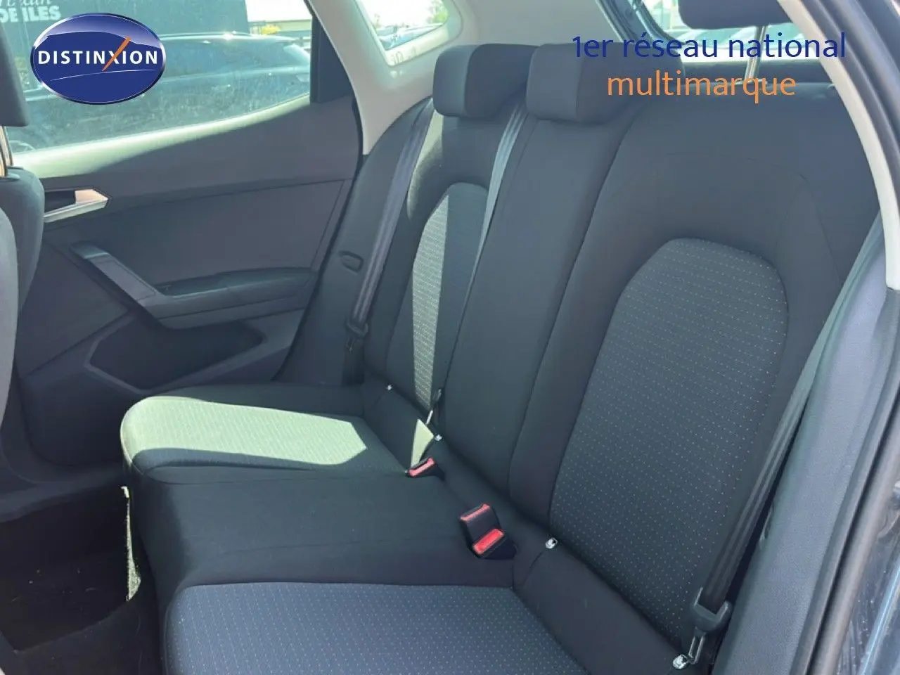 Vue intérieure de la banquette arrière côté droit d’un SEAT Arona gris avec sellerie tissu noir à motifs discrets.