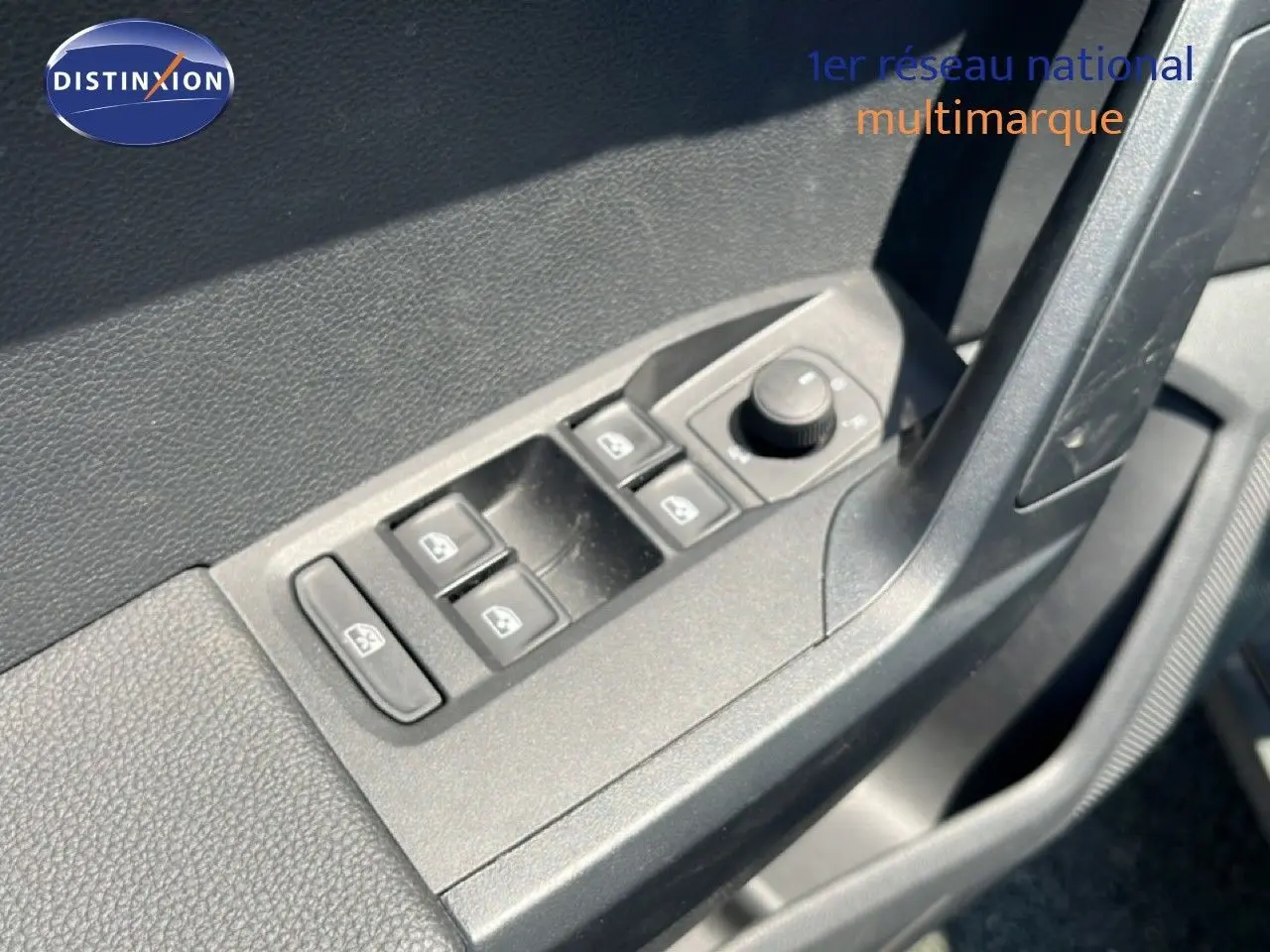 Gros plan sur les commandes des vitres et des rétroviseurs côté conducteur d’un SEAT Arona gris Magnetic 2025.