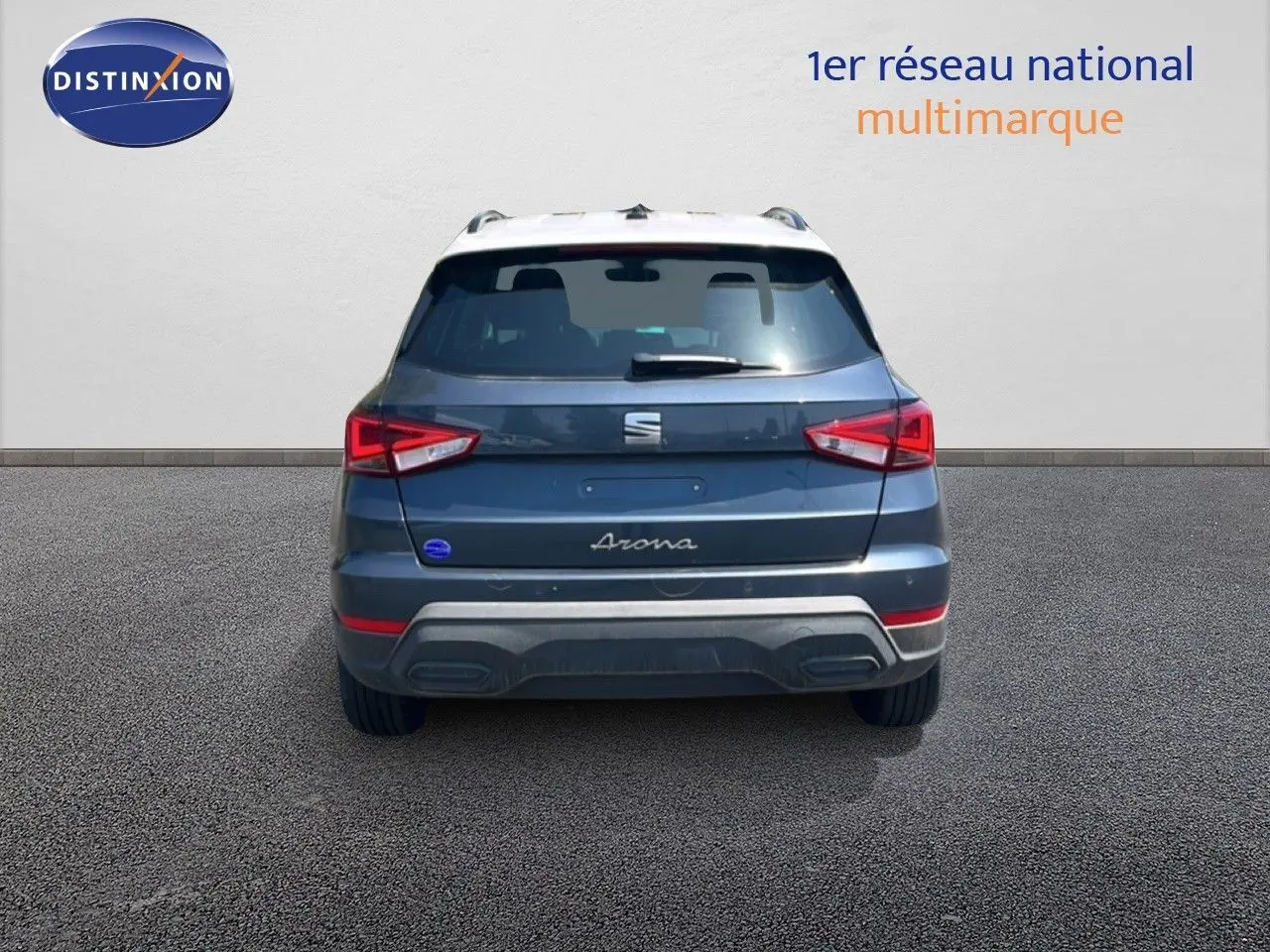 Vue arrière d'un SEAT Arona gris Magnetic avec toit blanc, montrant les feux arrière et le logo central.