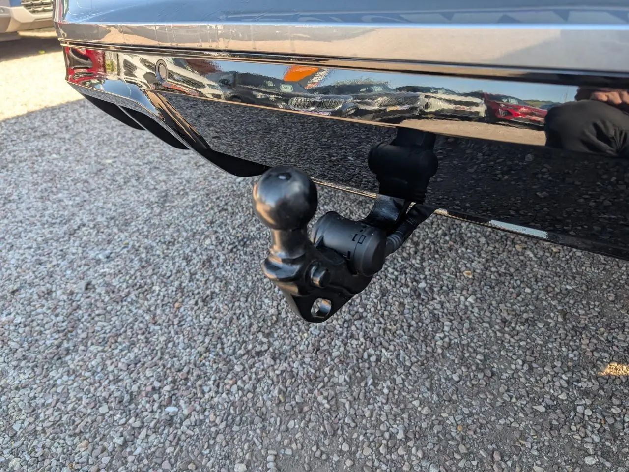 Gros plan sur le crochet d'attelage escamotable arrière du Volkswagen T-Roc gris métallisé, version R-Line.