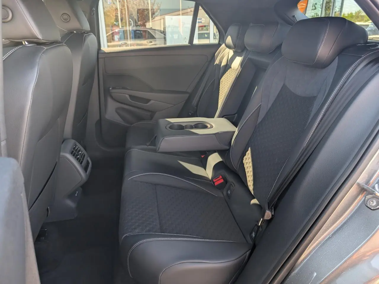 Vue latérale droite de la banquette arrière noire avec accoudoir central rabattable du Volkswagen T-Roc gris 2026 R-Line.