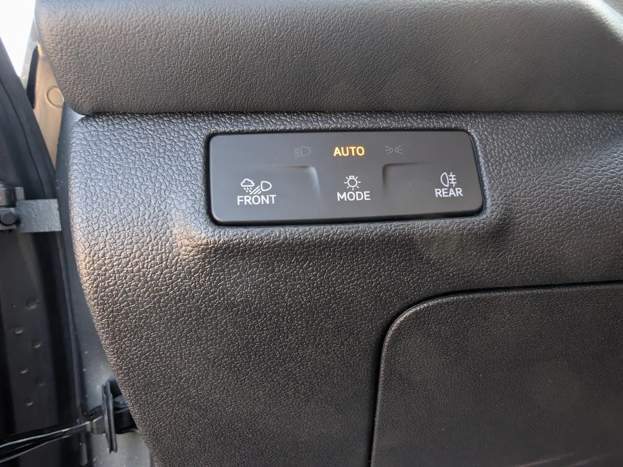 Gros plan sur le tableau de bord noir du Volkswagen T-Roc 2026 montrant les commandes d'éclairage automatiques.