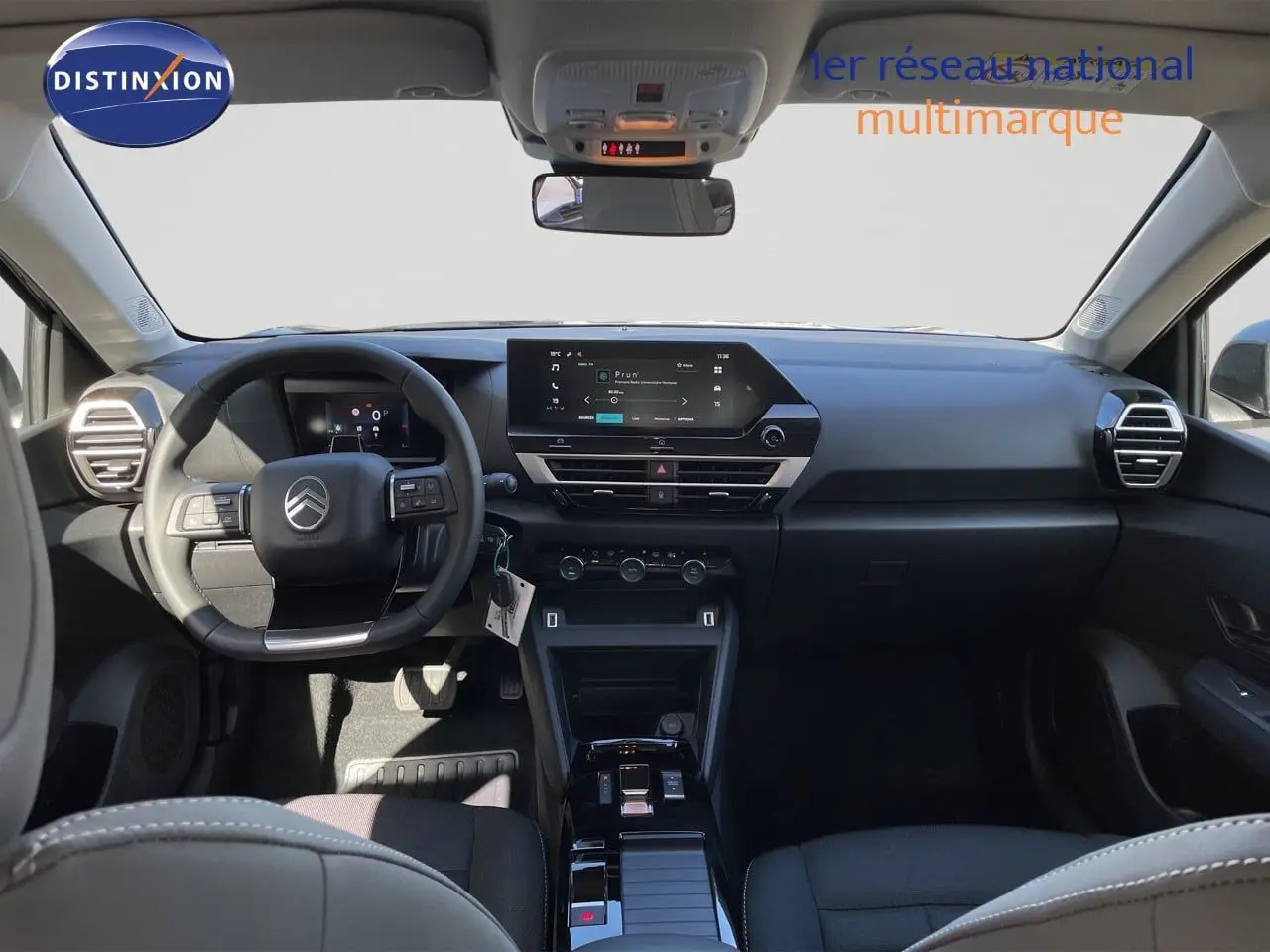 Vue intérieure avant du Citroën C4 Hybrid 145ch avec tableau de bord noir et écran tactile central lumineux.