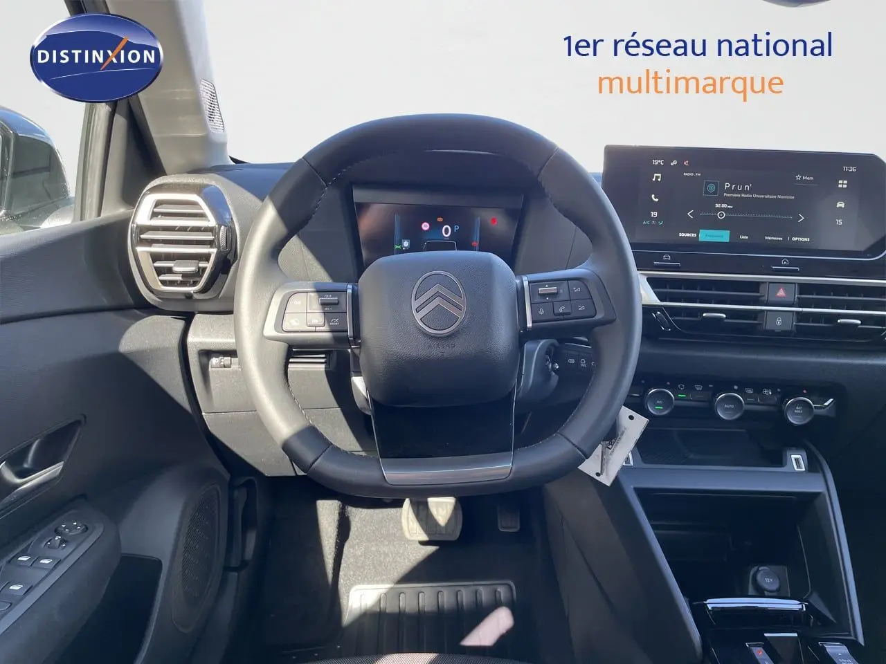 Vue intérieure centrée sur le volant Citroën C4 Hybrid 2026, avec tableau de bord numérique et écran tactile moderne.