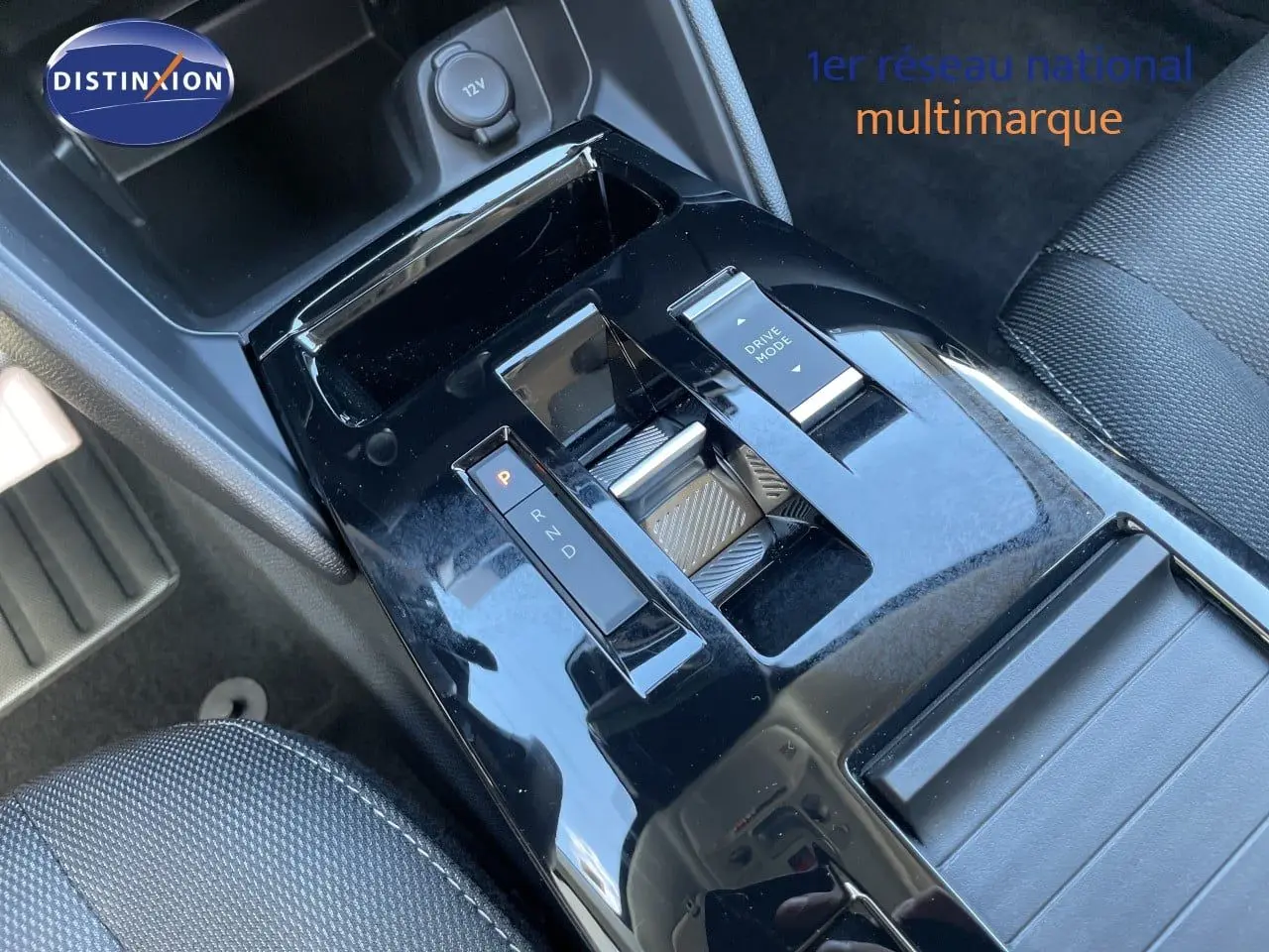 Gros plan sur la console centrale noire brillante de la Citroën C4 Hybrid 145ch avec sélecteur de boîte auto et bouton Drive Mode.
