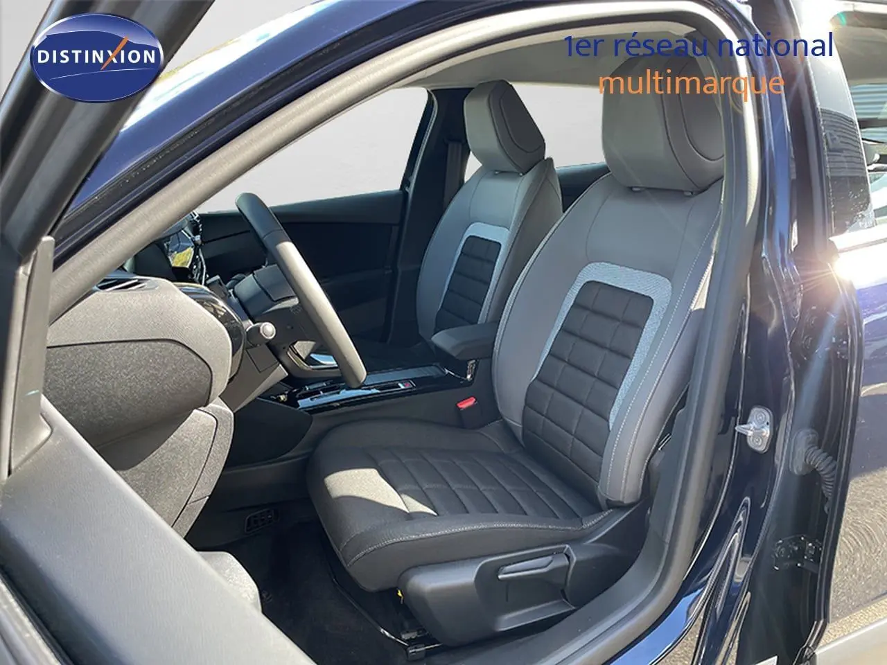 Vue intérieure côté conducteur de la Citroën C4 Hybrid 145ch bleu eclipse métal, sièges tissu noir et gris.