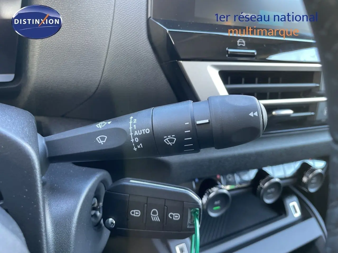 Gros plan sur la commande d’essuie-glace et la clé de contact dans l’habitacle d’une Citroën C4 hybride 2026.