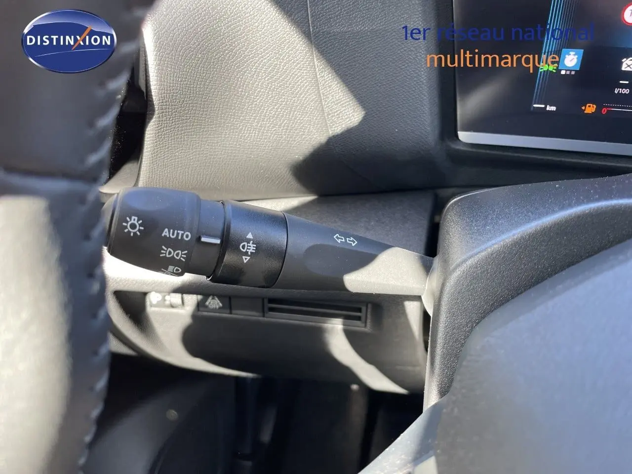 Gros plan sur la commande des feux et clignotants à gauche du volant d’une Citroën C4 hybride 2026.