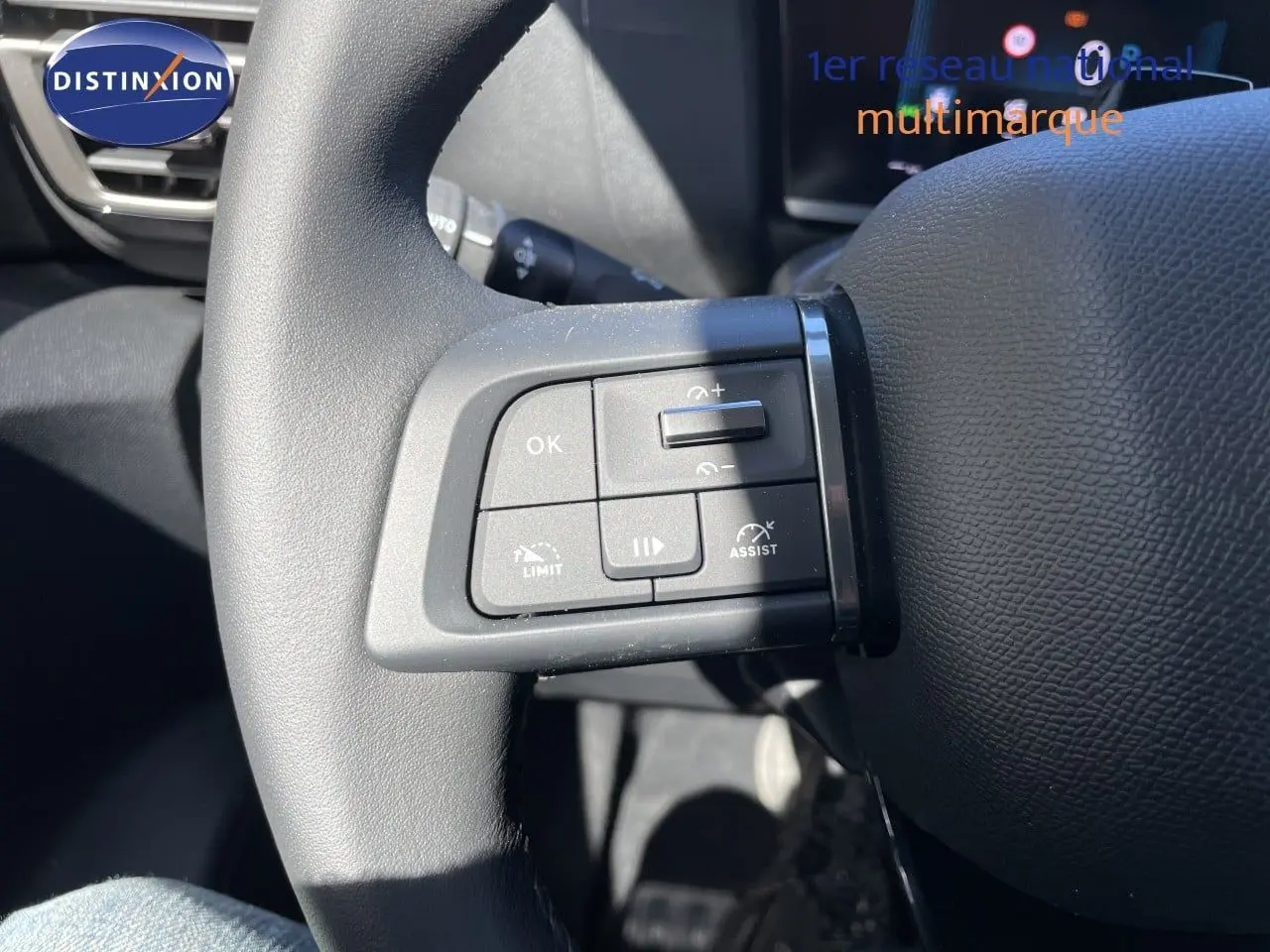 Gros plan sur les commandes de régulateur de vitesse au volant d’une Citroën C4 hybride 2026, intérieur noir.