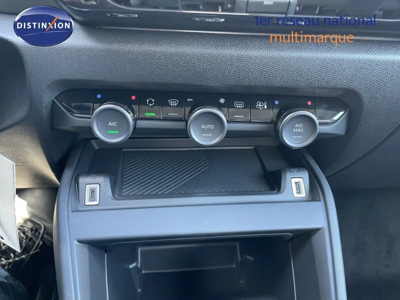 Vue rapprochée de la console centrale avec commandes de climatisation et ports USB d’une Citroën C4 hybride.
