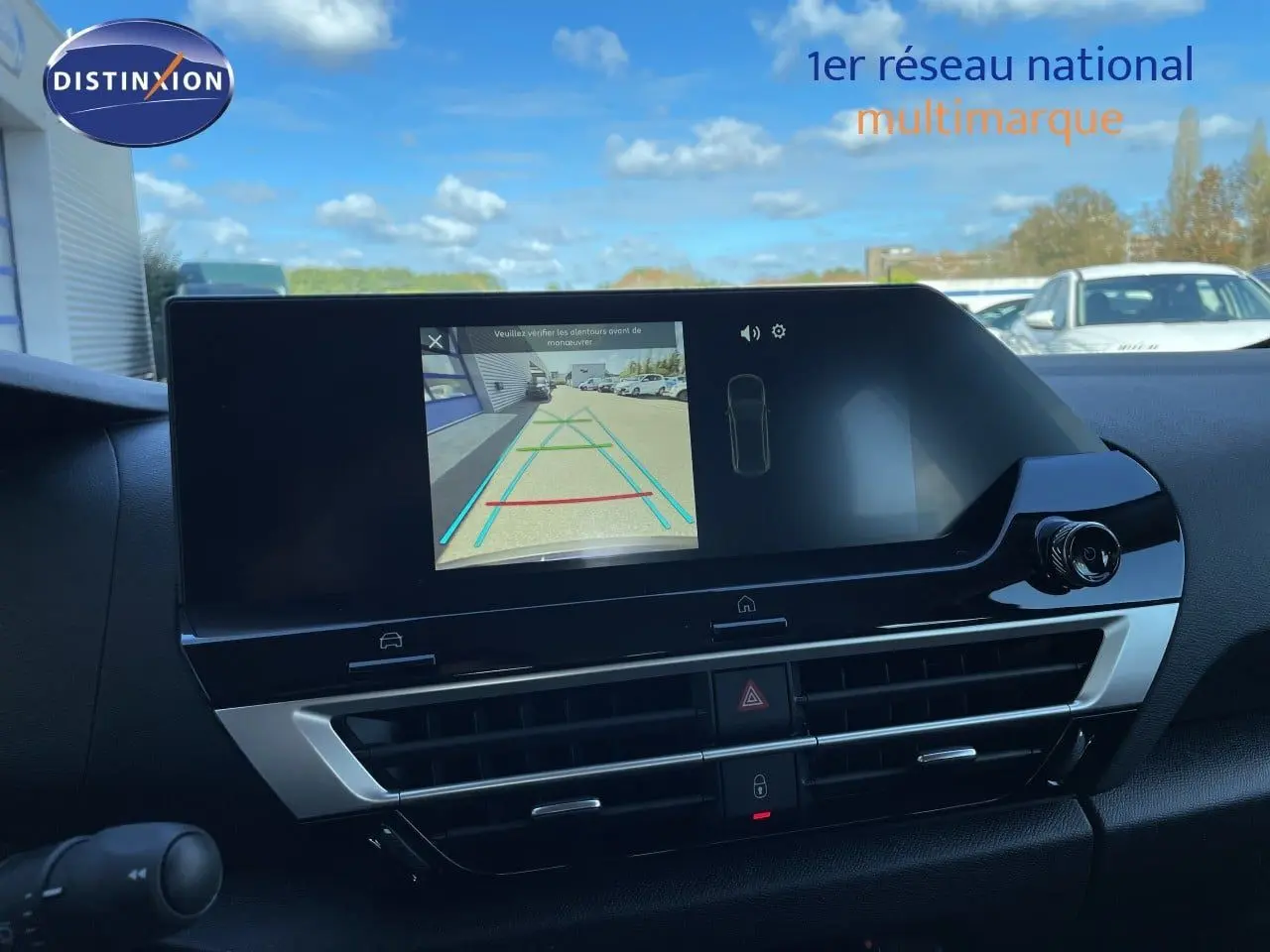 Écran central de la Citroën C4 Hybrid 145ch bleu Eclipse Metal montrant la caméra de recul et la console noire brillante.