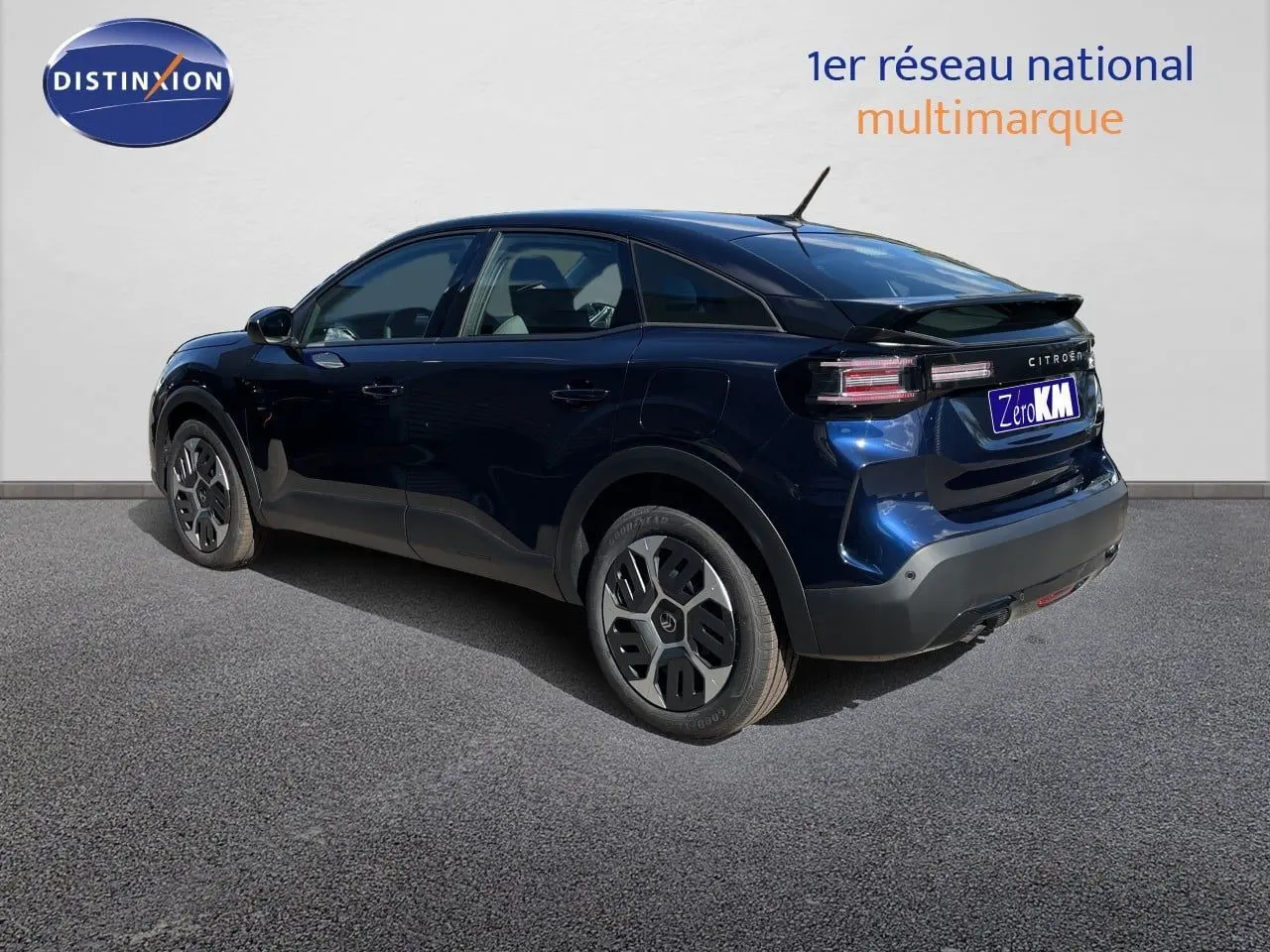 Vue 3/4 arrière droite d'une Citroën C4 hybride bleu eclipse metal avec jantes spécifiques et toit noir.