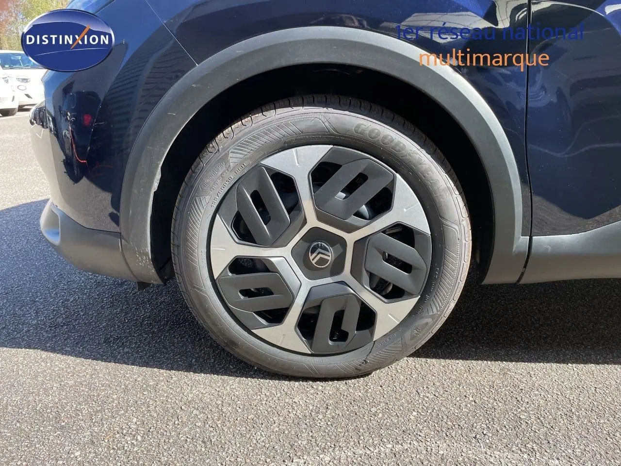 Gros plan sur la roue avant droite d'une Citroën C4 bleu eclipse métal avec jante au design géométrique.
