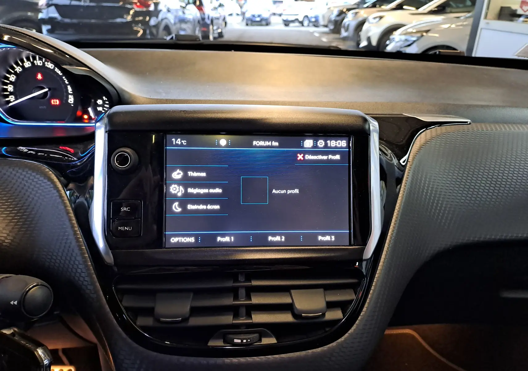 Vue rapprochée du tableau de bord noir du Peugeot 2008 gris, mettant en valeur l'écran tactile central allumé.