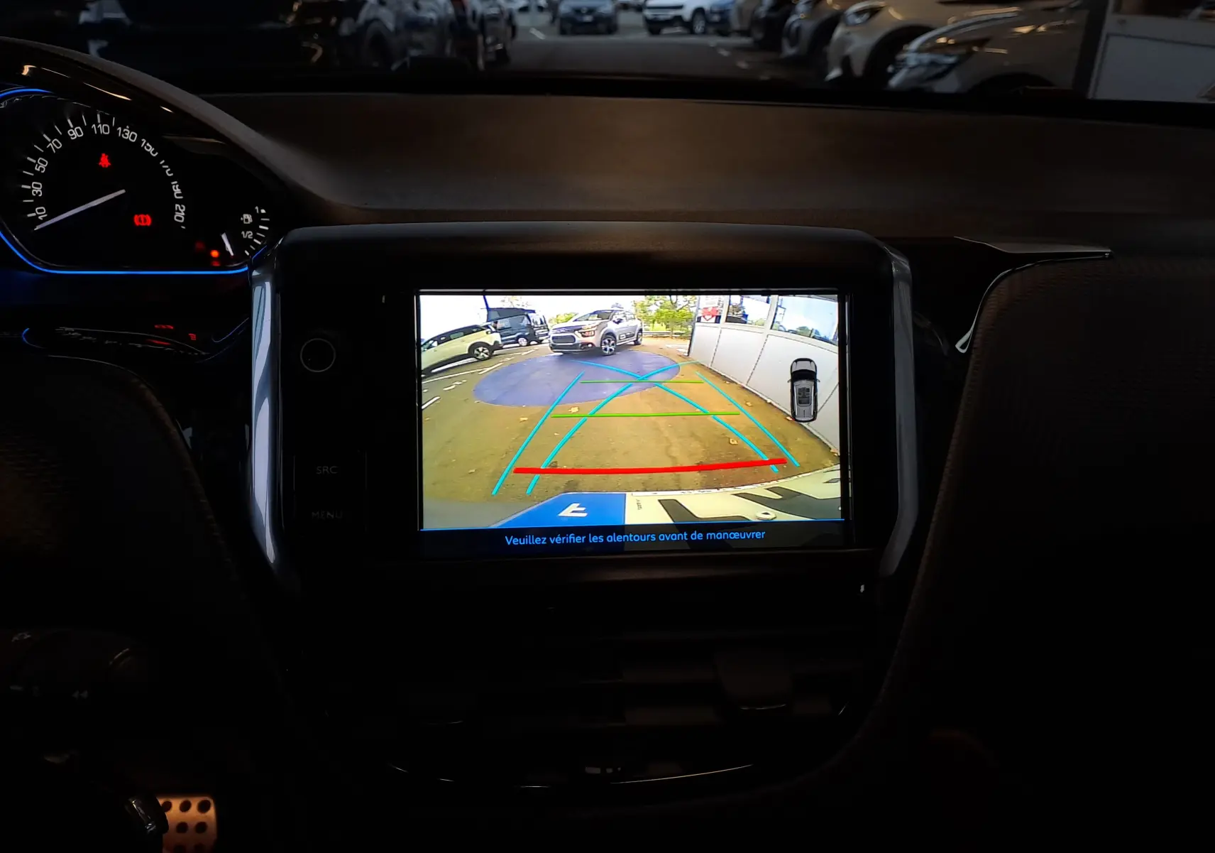 Vue intérieure du tableau de bord du Peugeot 2008 gris 2019, avec écran de caméra de recul affichant l'arrière du véhicule.