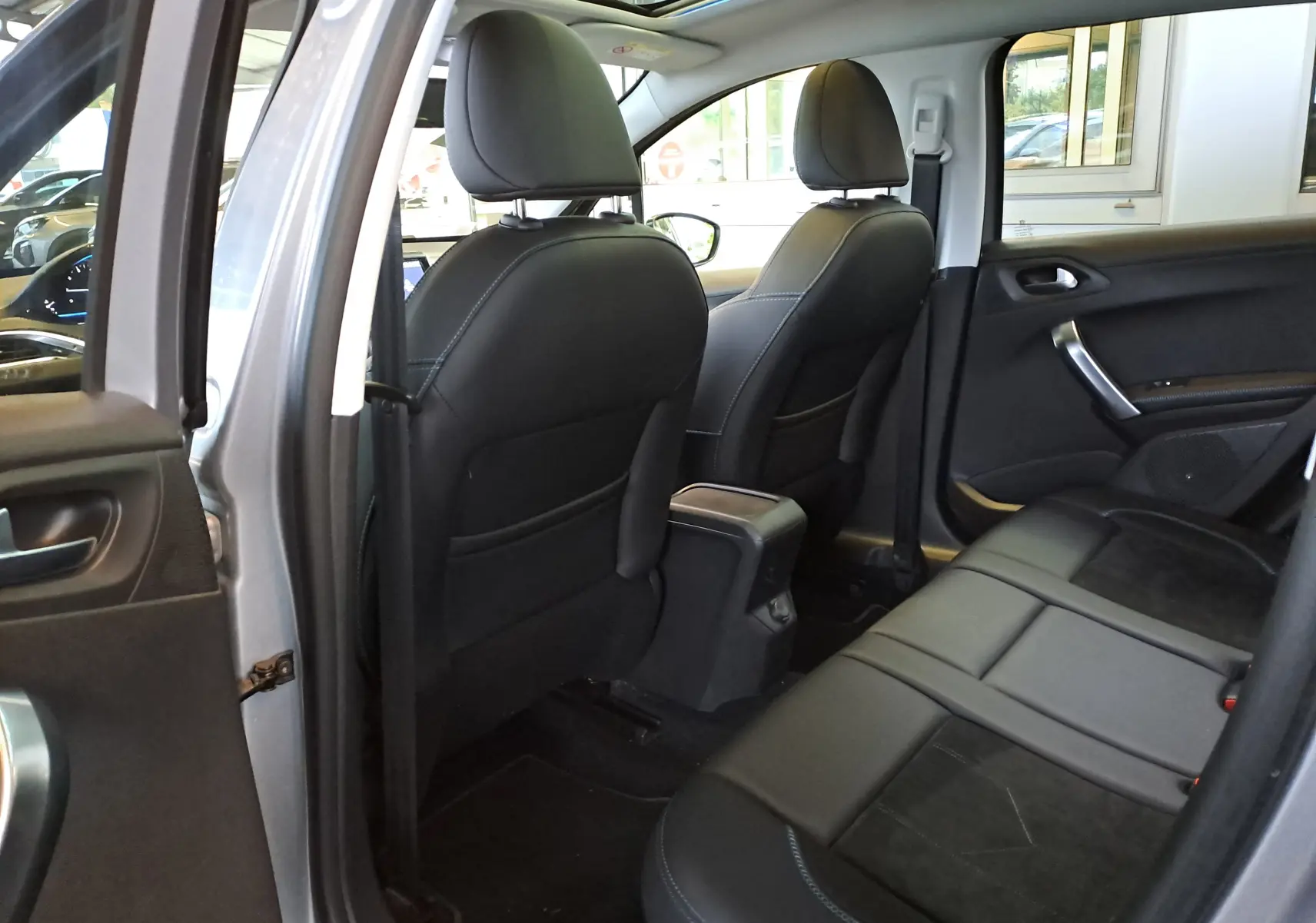Vue intérieure arrière droite du Peugeot 2008 gris de 2019, montrant les sièges noirs en cuir et alcantara avec détails contrastants.