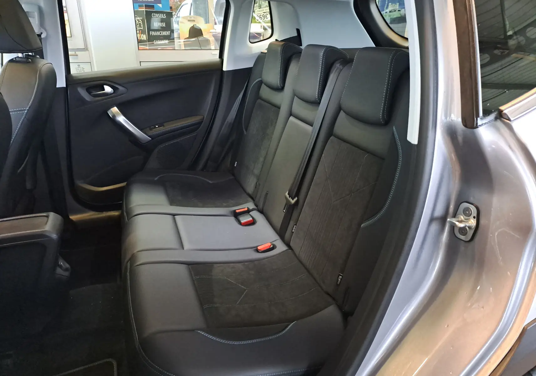 Vue intérieure côté droit des sièges arrière en cuir noir du Peugeot 2008 gris 2019, avec finitions contrastées.