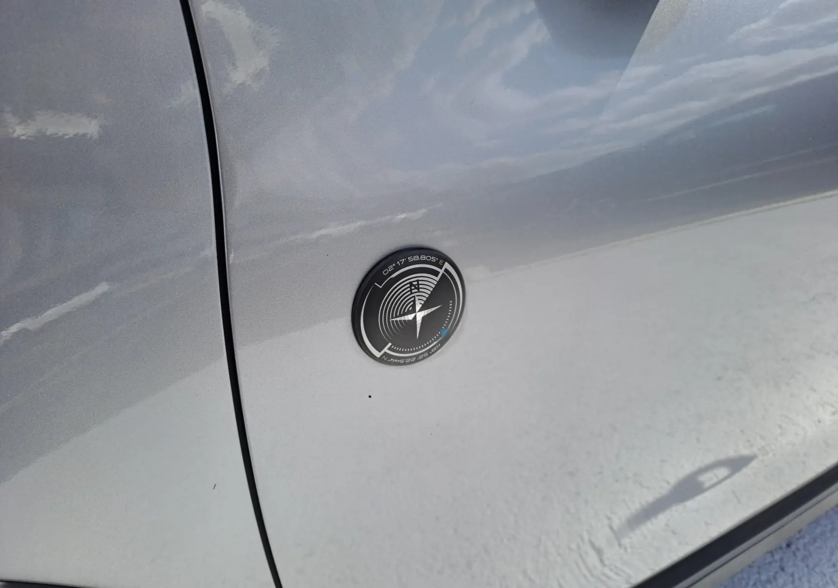 Gros plan sur l'écusson noir et argenté sur la porte côté gauche d'un Peugeot 2008 gris 2019.