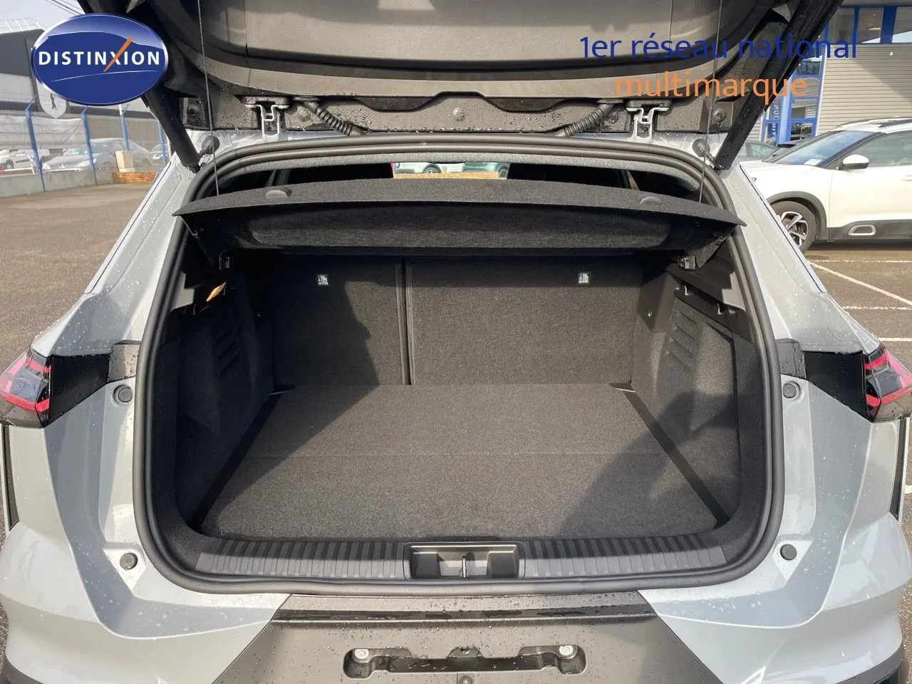 Coffre ouvert vu de l'arrière d'une Renault Symbioz gris Rafale 2024, montrant un espace de chargement spacieux.