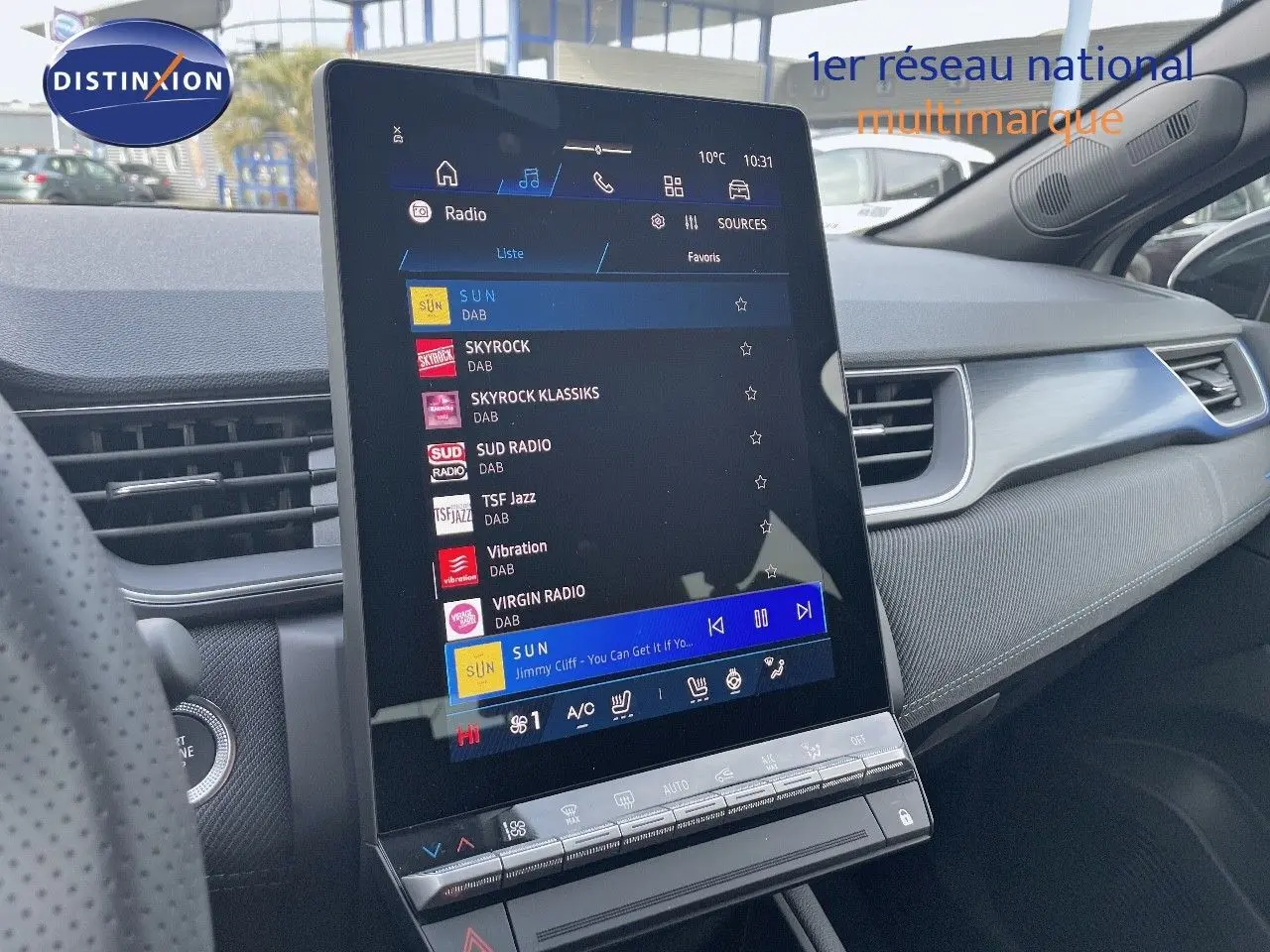 Vue intérieure centrée sur l'écran tactile vertical du tableau de bord du Renault Symbioz gris Rafale, avec commandes climatisation visibles.