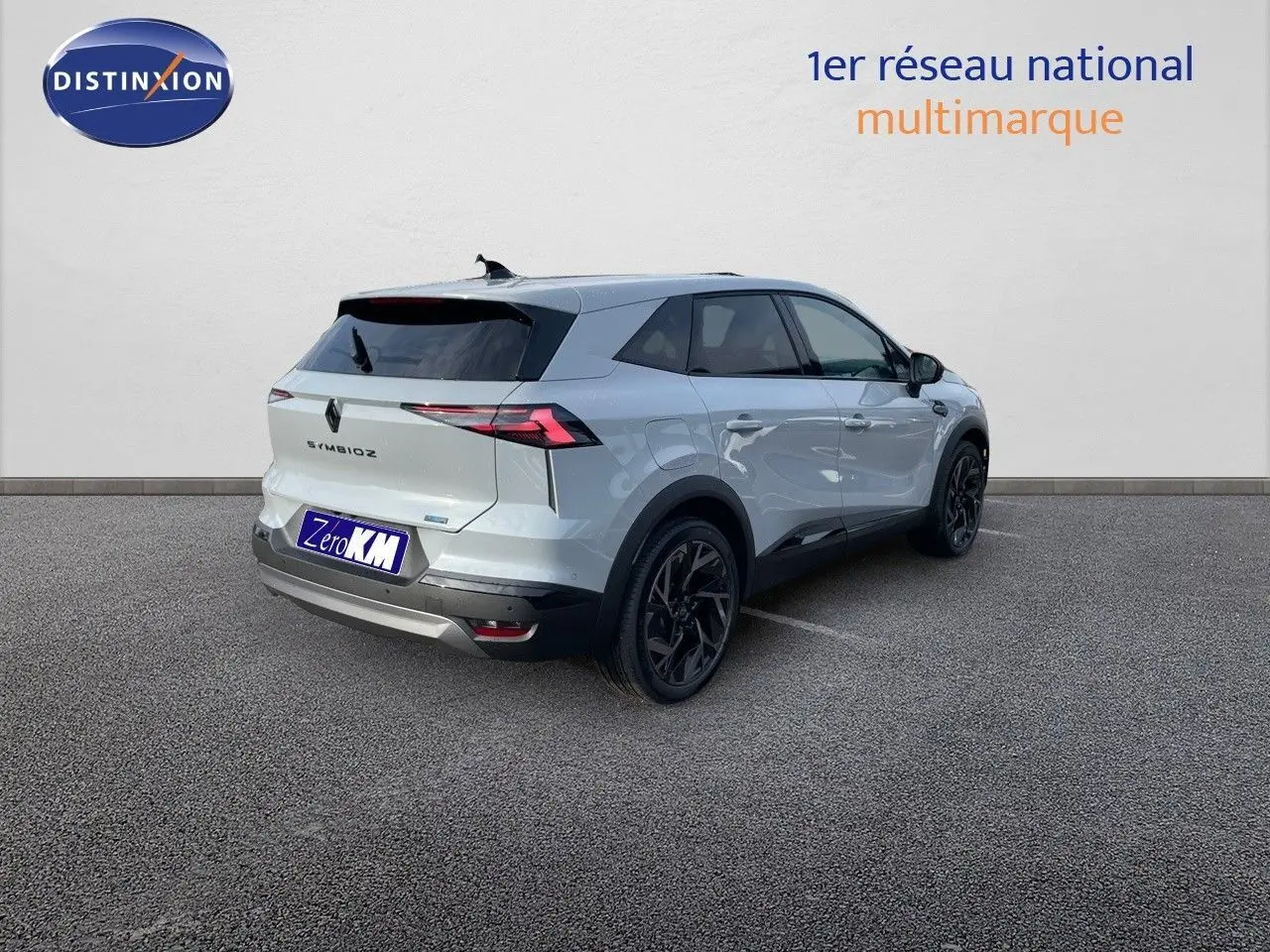 Renault Symbioz gris Rafale vu en 3/4 arrière droit, avec jantes noires et feux arrière LED distinctifs.